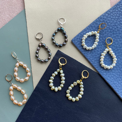 Yellow Athena pearl drop earrings featuring elegant white pearl pendants hanging from gold-tone earrings.