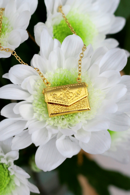 Ultramarine Birch 24 Karats Daisy Envelope Locket Necklace featuring a gold-toned floral envelope pendant on a delicate chain.