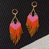 Yellow Athena LOVE earrings featuring pink and orange ombre fringe, with long, dangling earring design and colorful tassel accents.
