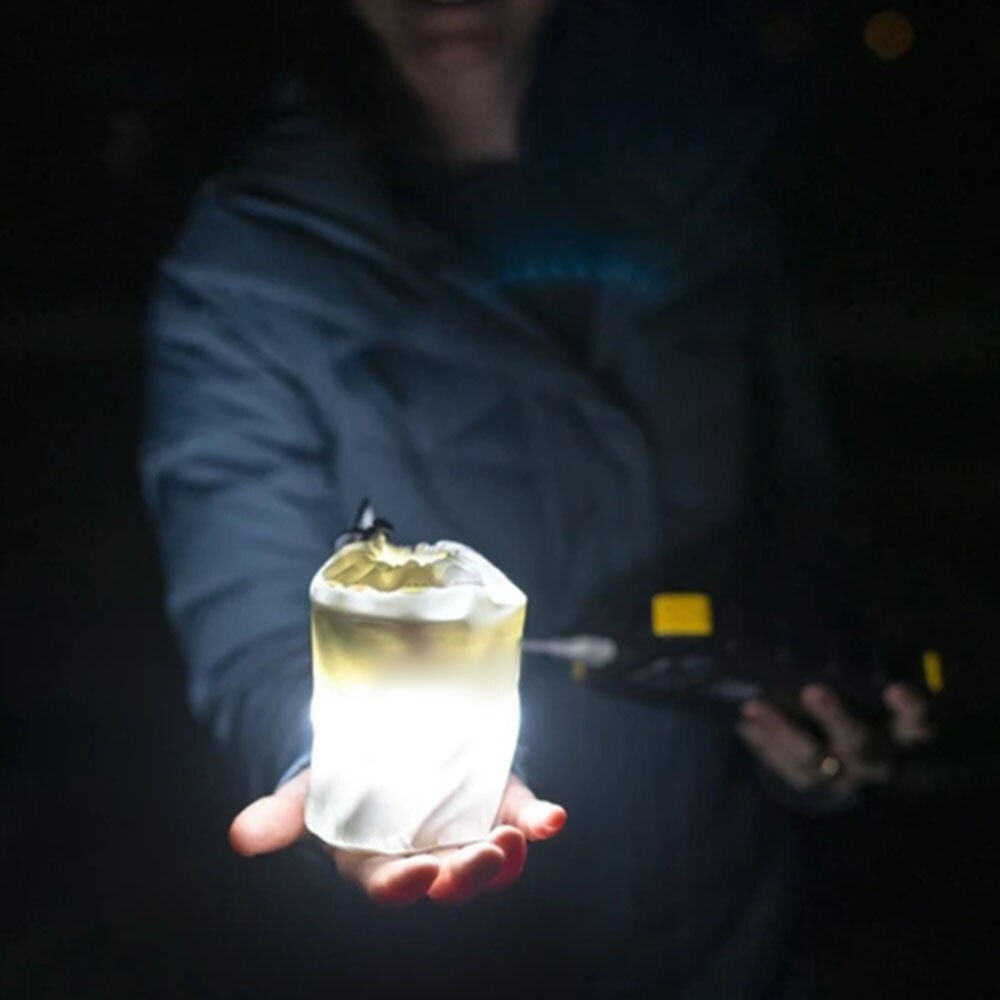 Teal Simba portable inflatable camping lamp glowing in a camping tent, lightweight and versatile for outdoor use.