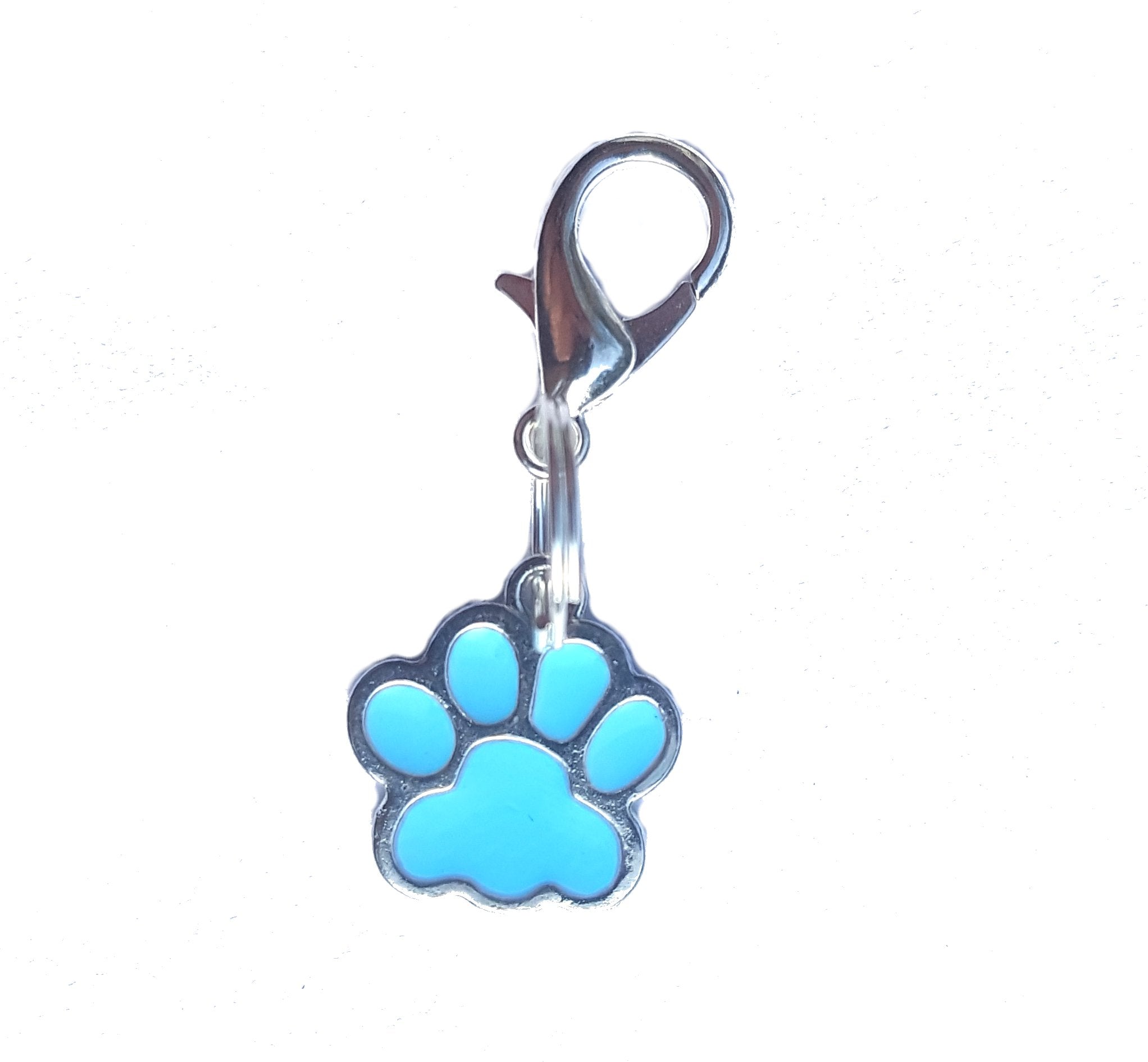 Salmon Oscar Paw cat and dog collar charms attached to a pet collar, showing playful paw designs on a colorful background.