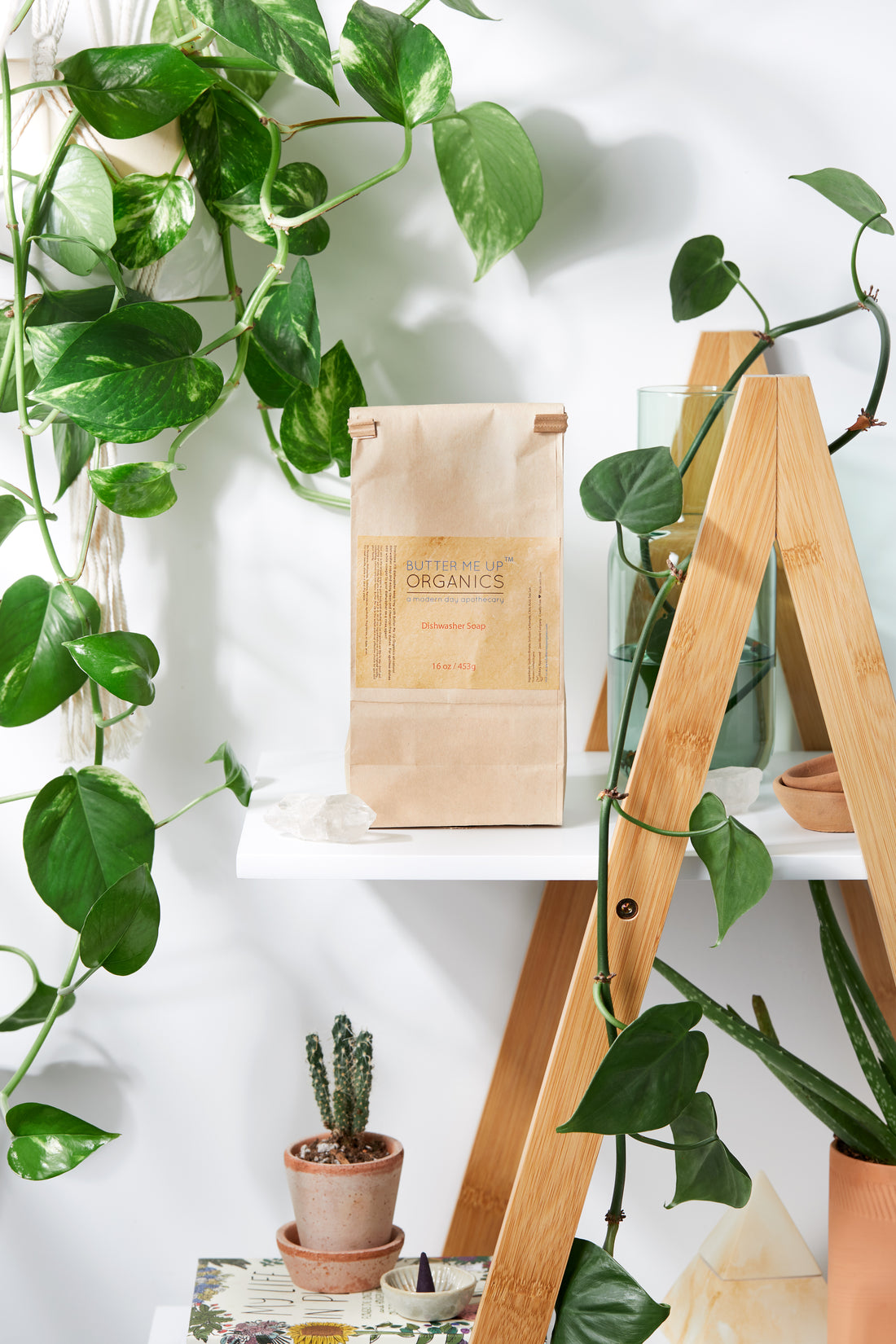 White Smokey all natural dishwasher soap in a kitchen setting, showcasing eco-friendly dishwashing product in a clear container.