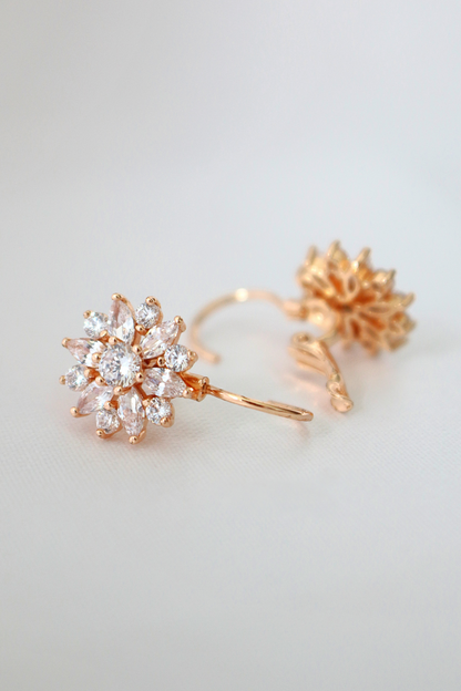 Diamond sunflower huggies earrings in 18 karat gold plating by Ultramarine Birch, featuring sunflower and diamond design.