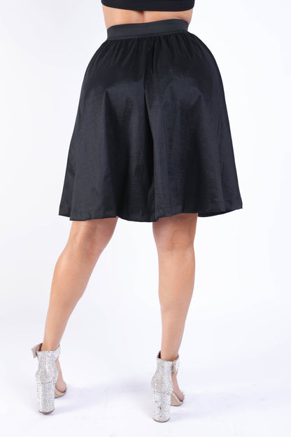 Black pleated midi flare skirt with high waist and casual elastic waistband by Puce Juniper.