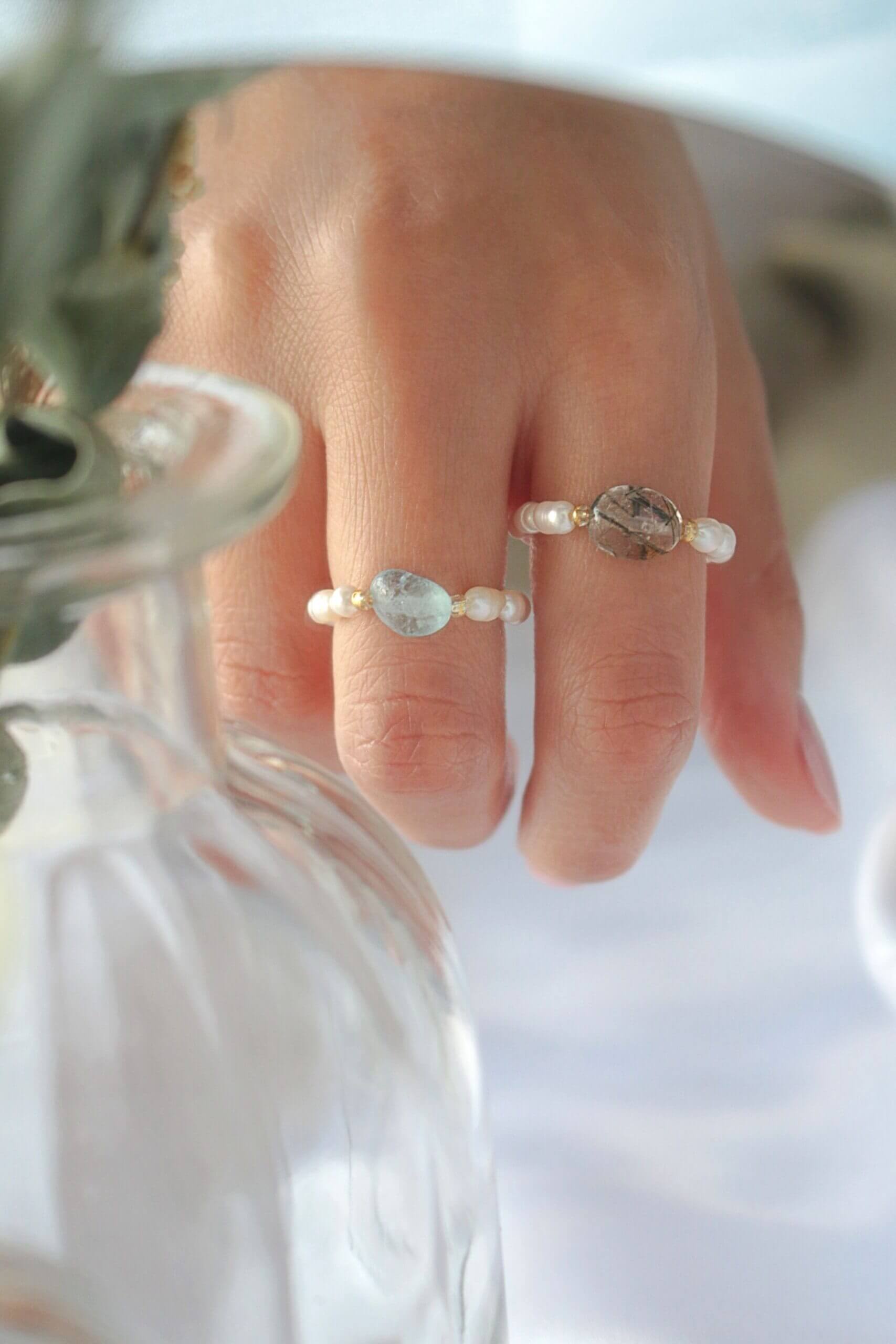 Elastic rings with natural crystals and freshwater pearls by Ultramarine Birch, showcasing elegant, colorful jewelry designs.