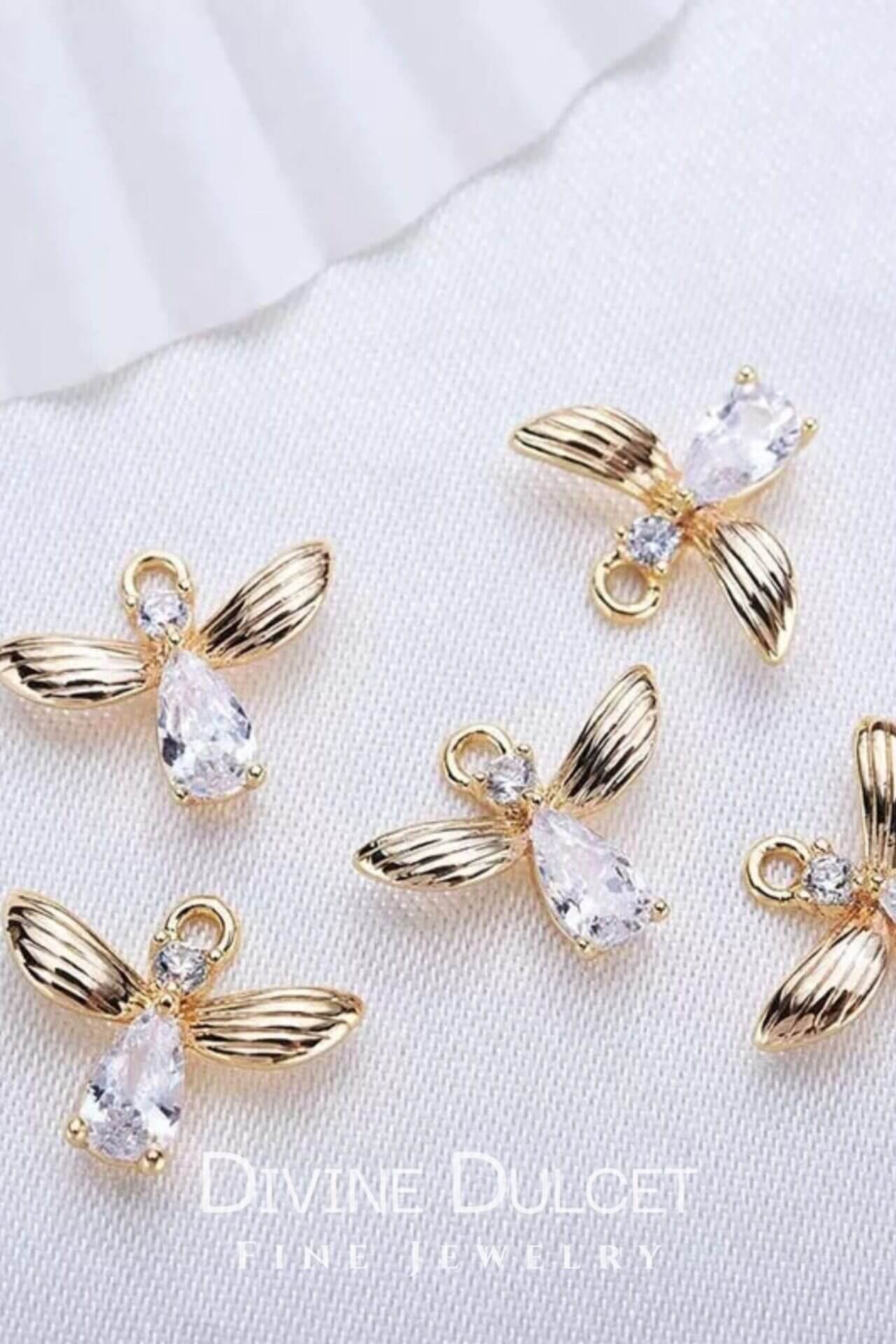 18 Karat Bee Hook Earrings by Ultramarine Birch, gold earrings with bee-shaped hook design, shiny and elegant jewelry accessory.