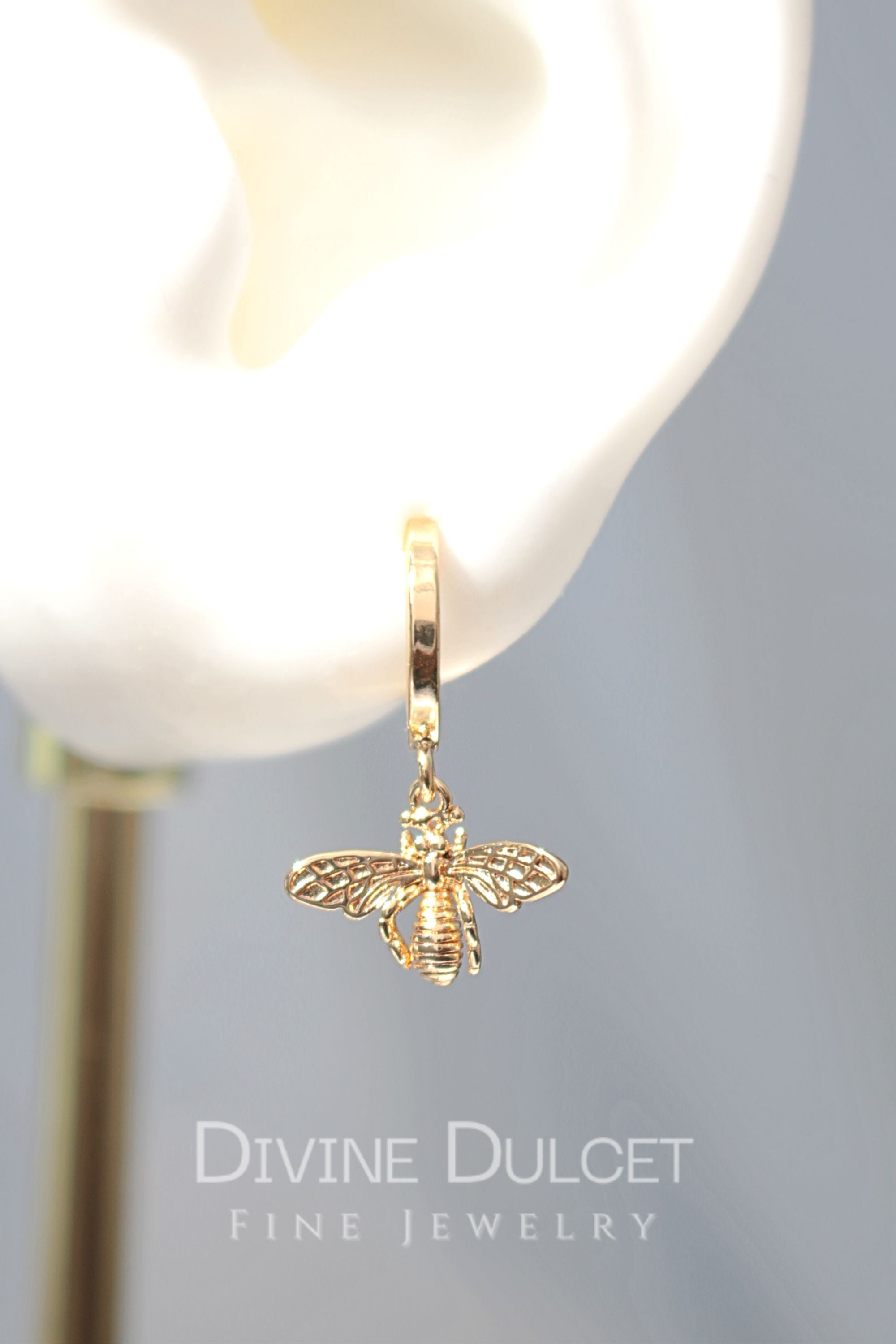 24 Karats gold bee hoop earrings by Ultramarine Birch featuring detailed bee charms on round hoop earrings.