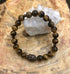 Violet Chaos Tiger Eye and Buddha gemstone bracelet with natural beads and intricate design, stylish and spiritual jewelry accessory.