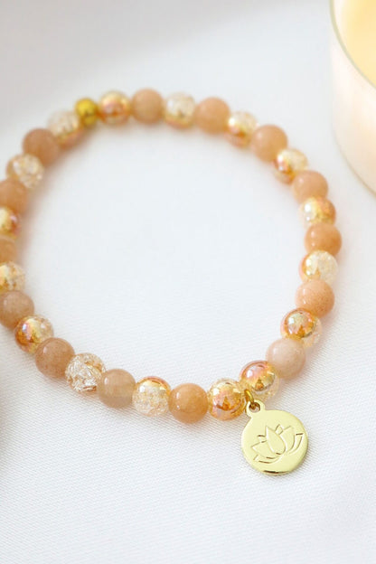 Sunstone elastic bracelet with 24K lotus flower charm by Ultramarine Birch featuring natural gemstone beads and delicate design.