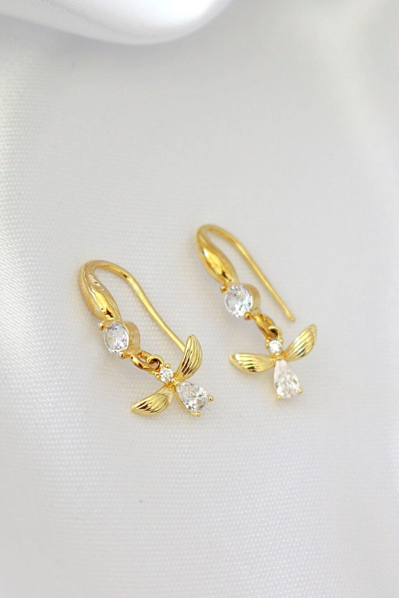 Ultramarine Birch 18K gold bee hook earrings featuring detailed bee-shaped design on shiny gold hooks.