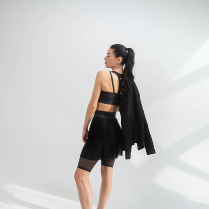 Indigo Thalassa MINI PLESSY MESH SKIRT shown in black with a fitted, sheer mesh design and subtle pleats.