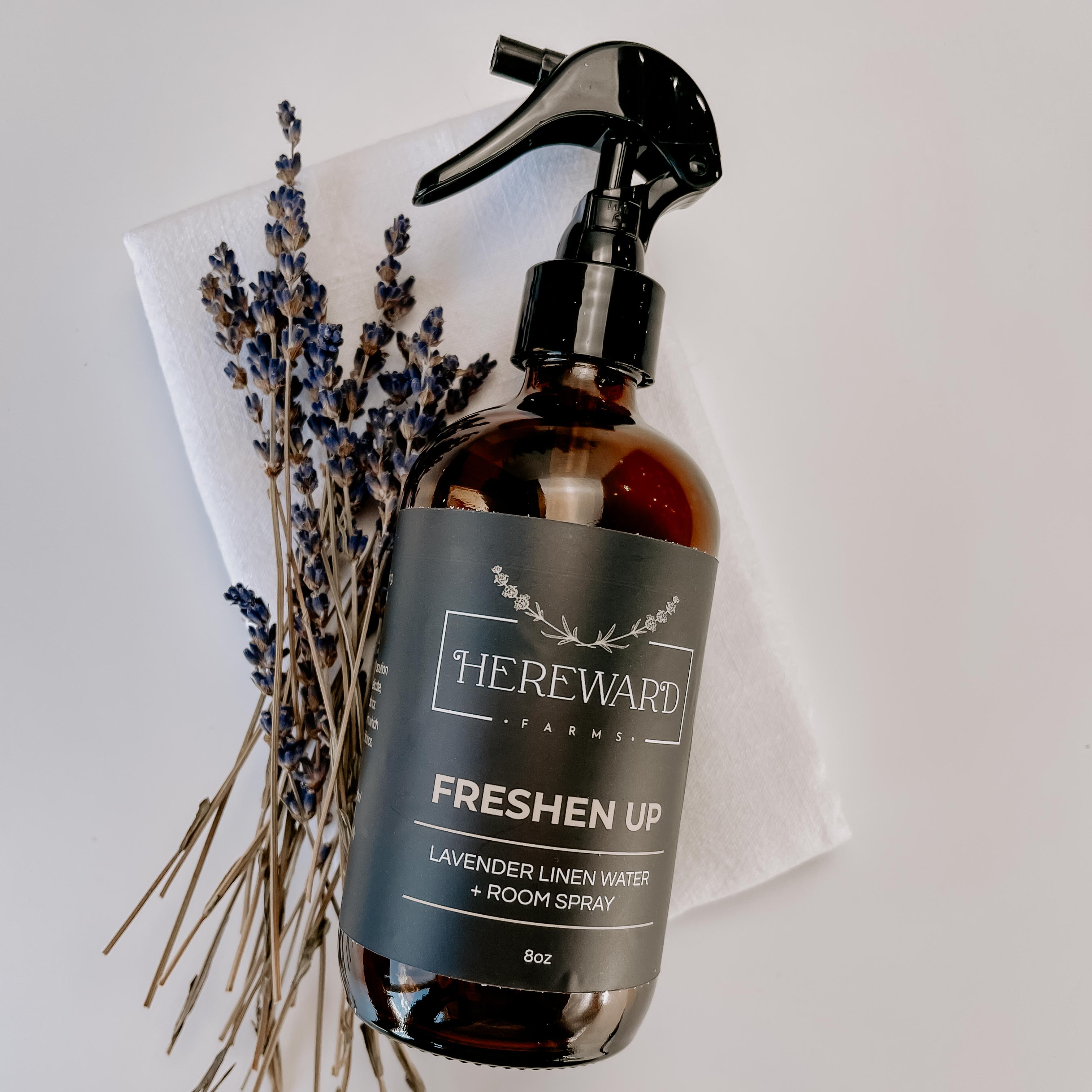 Periwinkle Poplar Freshen Up Linen and Room Spray in a bathroom setting, showcasing its elegant bottle and fresh scent.