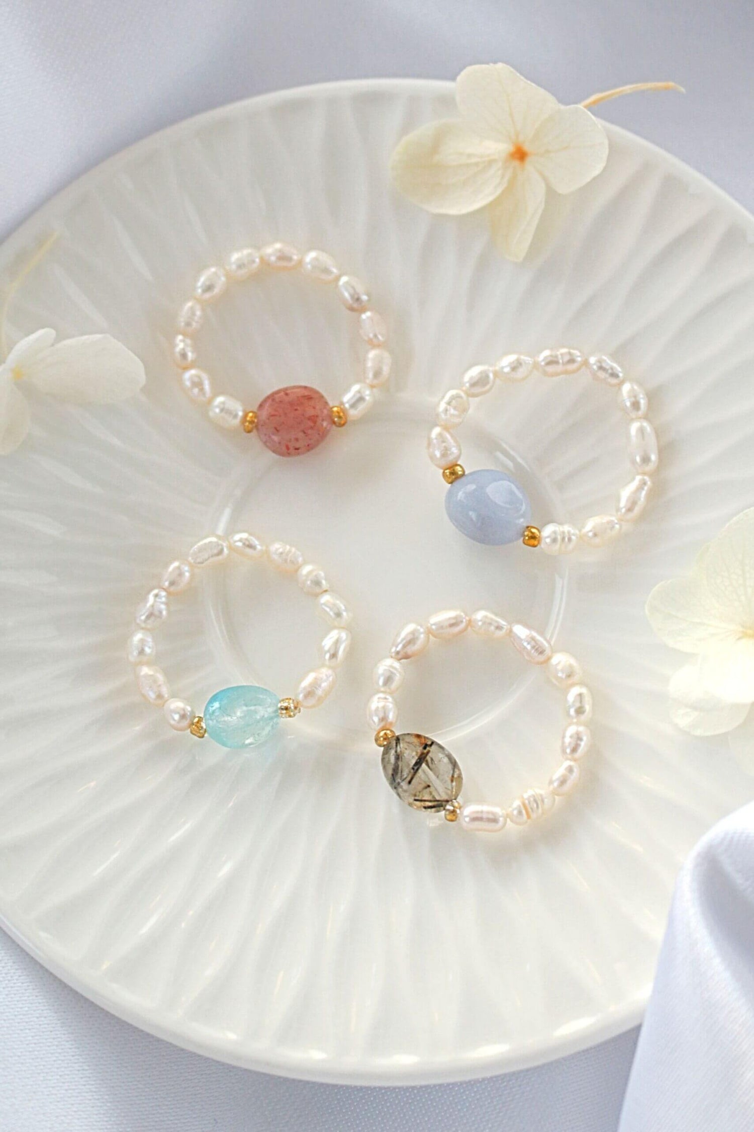 Ultramarine Birch elastic rings featuring natural crystals and freshwater pearls, showcasing delicate designs and vibrant materials.