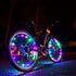 Colorful mini LED bike wheel spoke light by Lilac Milo, mounted on a bicycle wheel, creating vibrant illumination during biking.