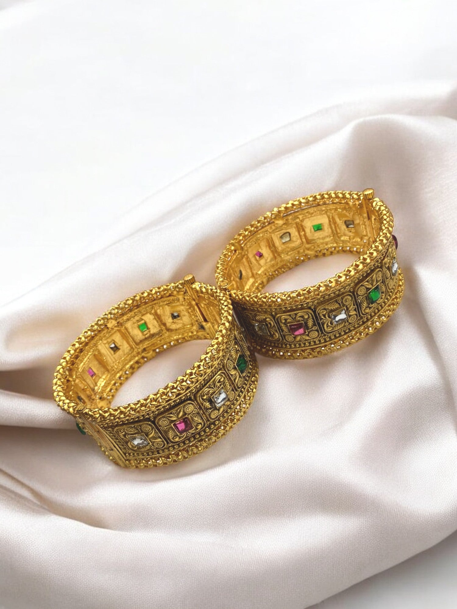 Gold-plated Indian bangles from Gray Poseidon with intricate traditional and modern bracelet designs on a neutral background.