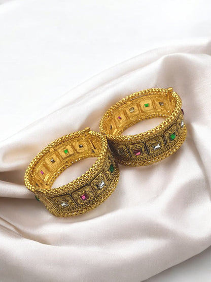 Gold-plated Indian bangles from Gray Poseidon with intricate traditional and modern bracelet designs on a neutral background.