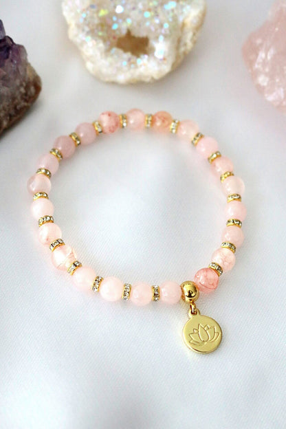 Ultramarine Birch rose quartz and amethyst elastic bracelet with a 24K gold lotus flower charm featuring natural gemstone beads.