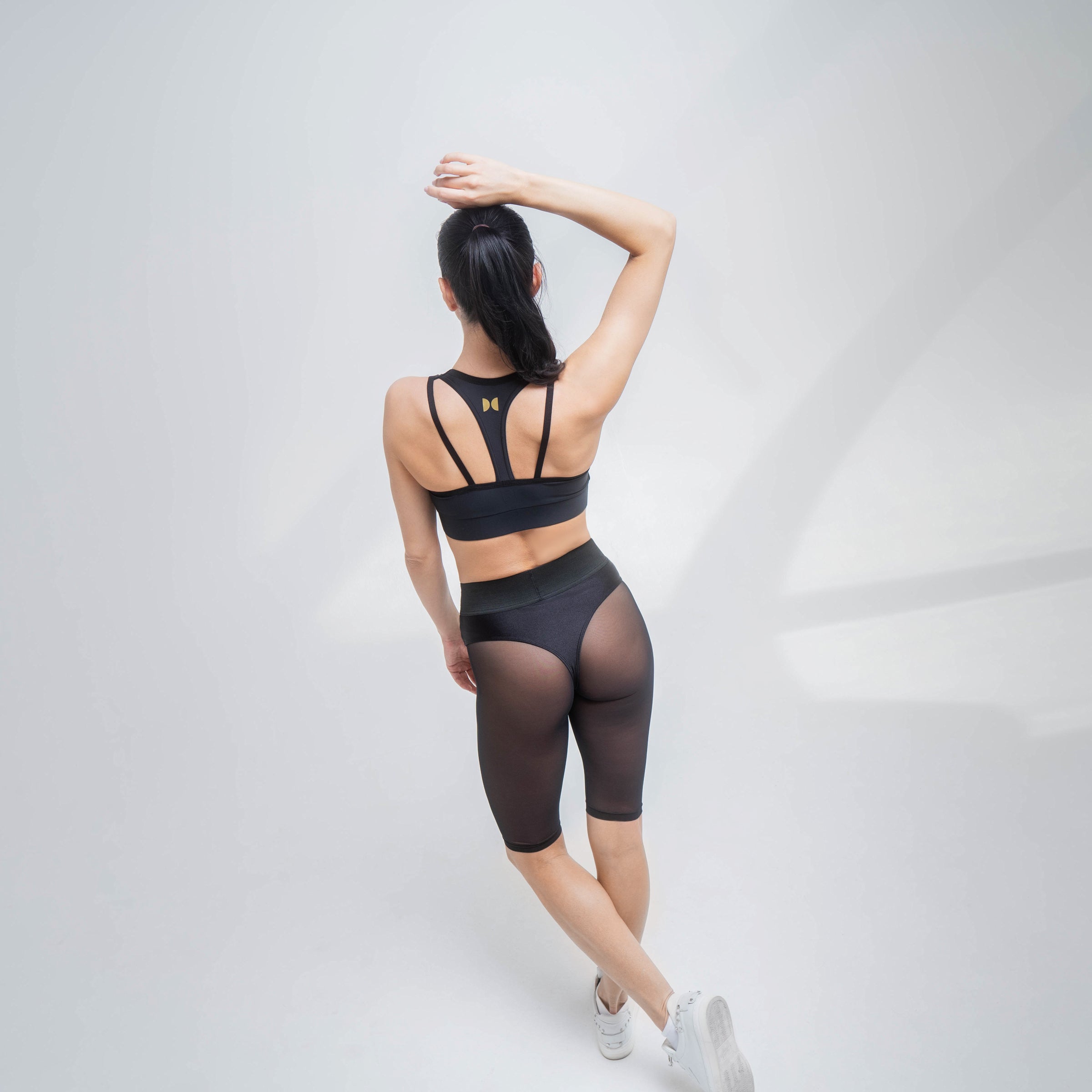 Black mesh shorts by Indigo Thalassa with breathable fabric and adjustable waistband, shown on a mannequin.