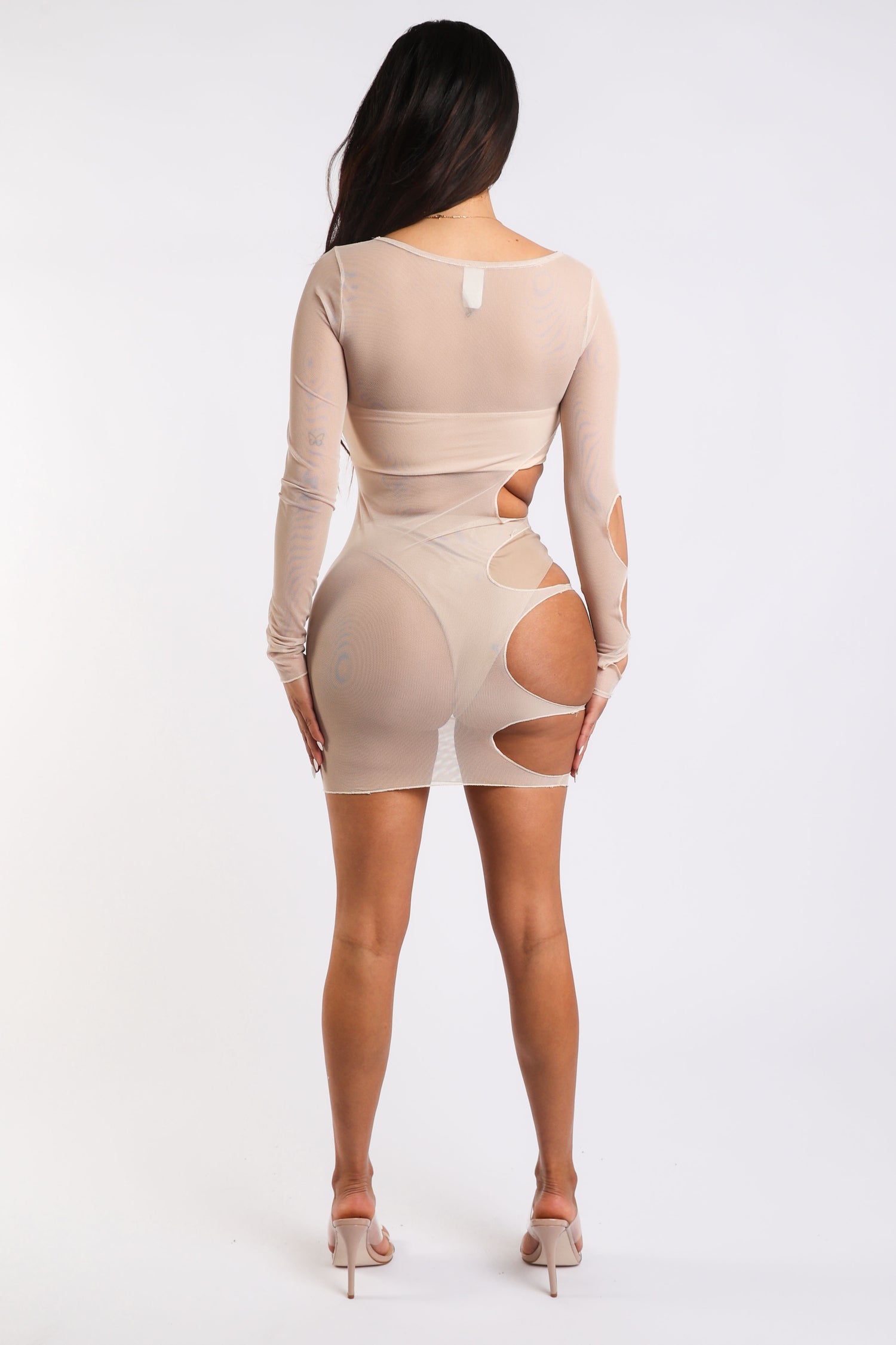 Nude long sleeve mesh dress with cut-out details by Puce Juniper, featuring sheer fabric and form-fitting design.