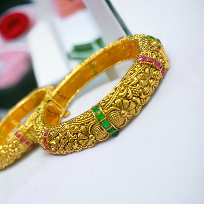 Gold-plated traditional bangles from Gray Poseidon, featuring intricate designs and a polished finish, displayed on a neutral background.