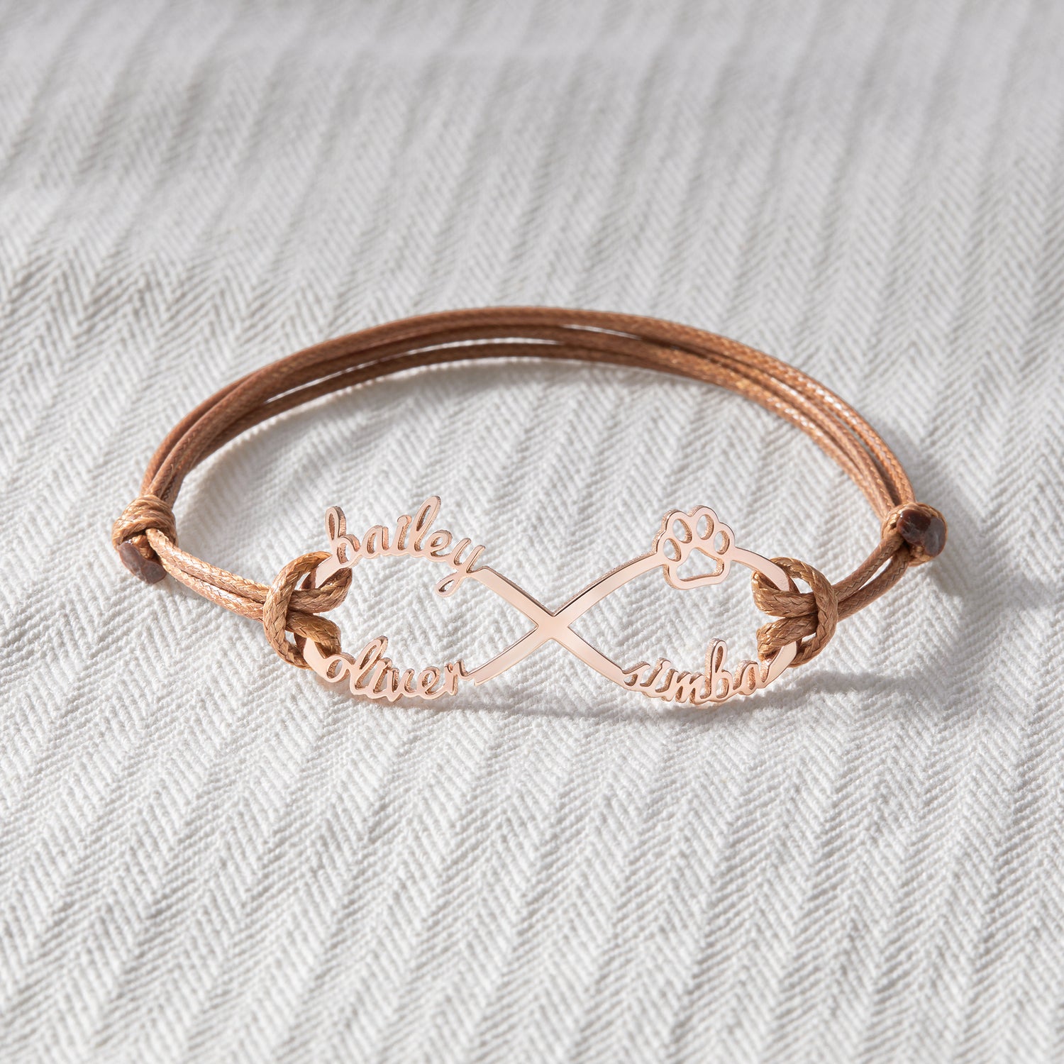 Green Millie custom pet name bracelet with engraved dog and cat motifs, designed as a heartfelt pet memorial bracelet.