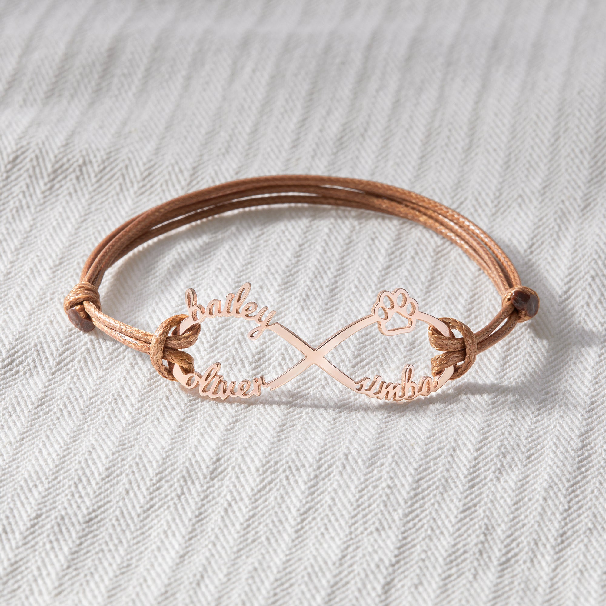 Green Millie custom pet name bracelet with engraved dog and cat motifs, designed as a heartfelt pet memorial bracelet.