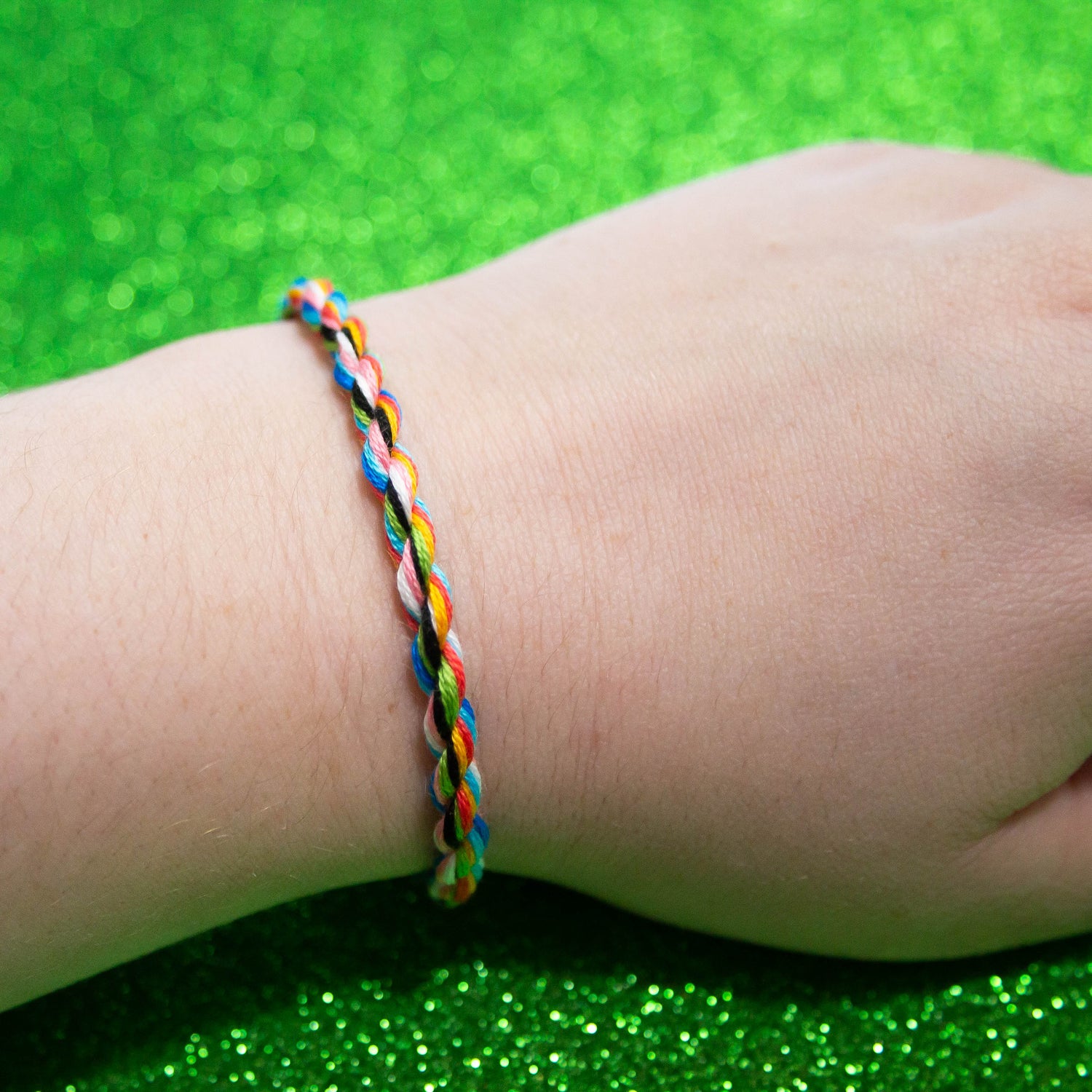 Handmade cotton bisexual friendship bracelet featuring colorful LGBTQ pride symbols, designed by Rose Erebus.