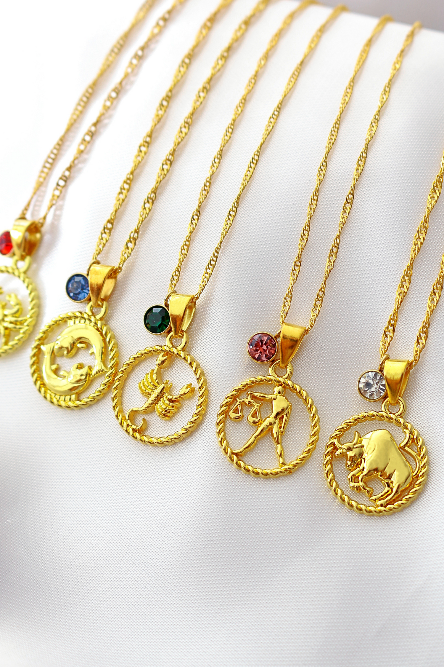 Ultramarine Birch 18K zodiac sign and birthstone necklace featuring a gold pendant with zodiac symbol and sparkling gemstone detail