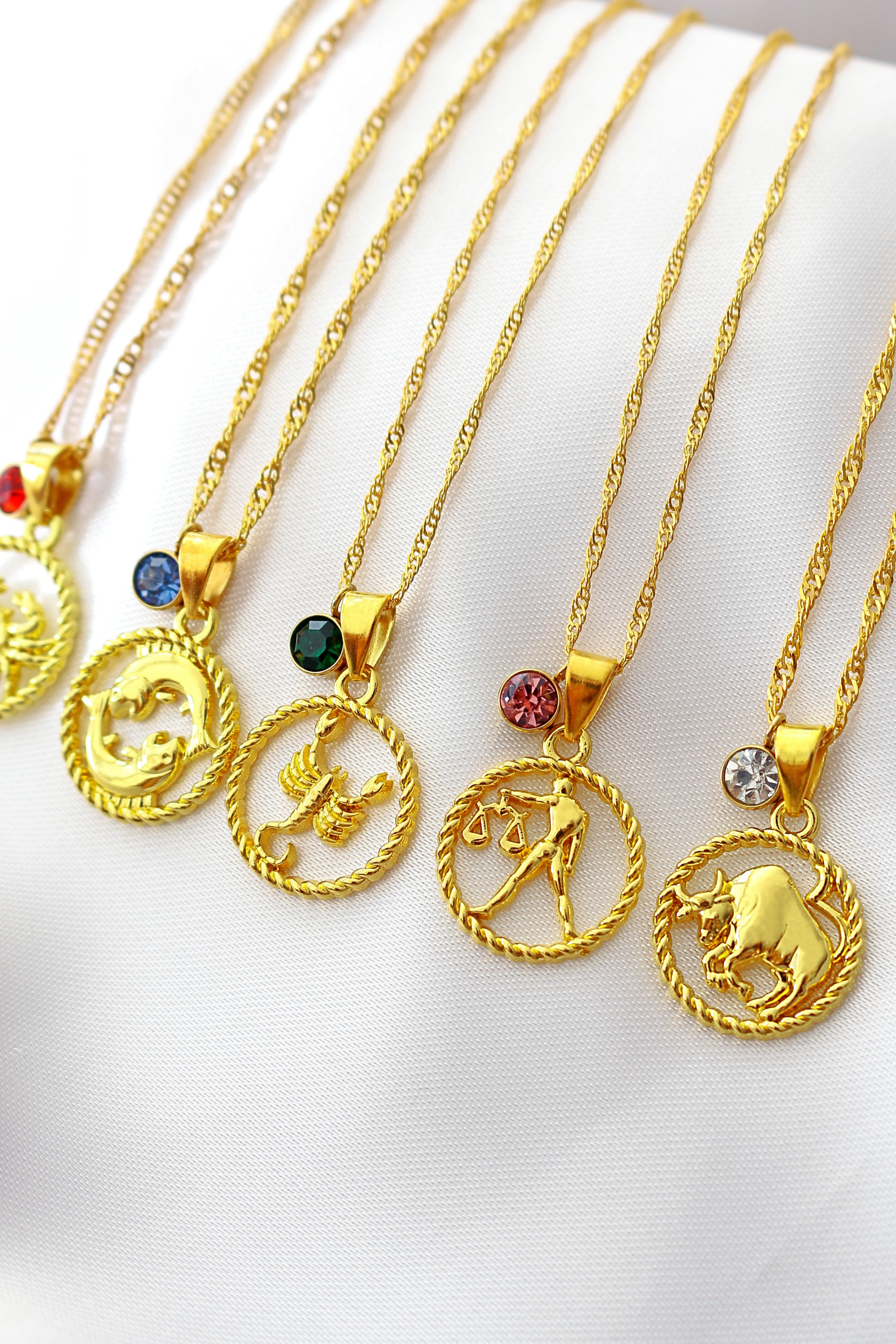 Ultramarine Birch 18K zodiac sign and birthstone necklace featuring a gold pendant with zodiac symbol and sparkling gemstone detail