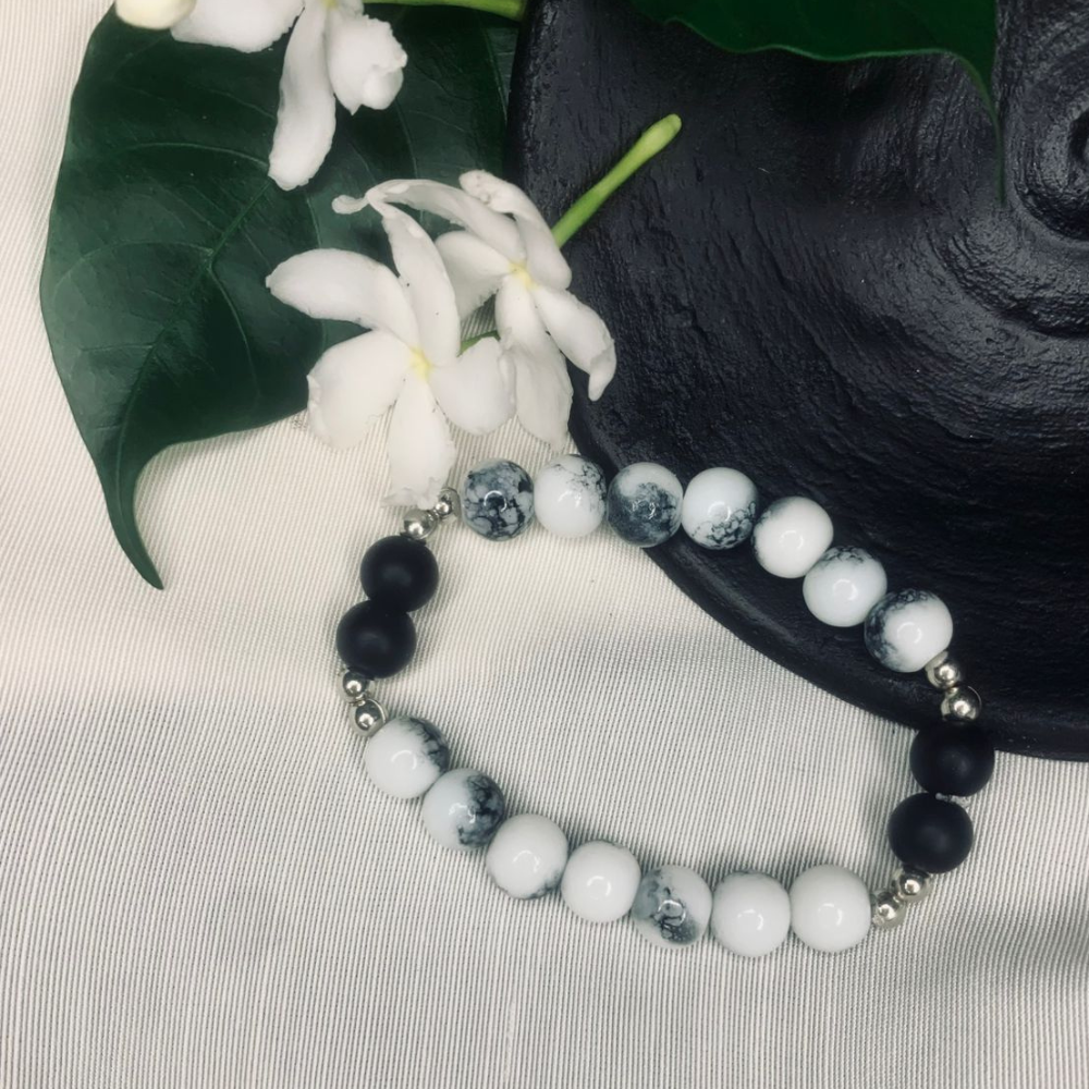 Howlite and black onyx stretch bracelet with silver spacers, featuring smooth polished beads, by Tan Saffron.