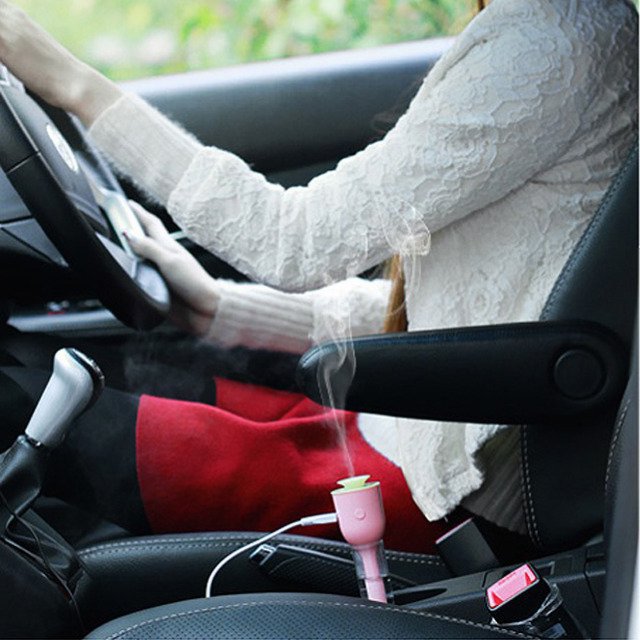 Fuchsia Molly Mini USB Magic Wand Humidifier in automotive use, showing compact design and misting nozzle for personal humidification.