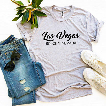 Agate Sin City Nevada T-shirt featuring bold Las Vegas skyline and iconic neon lights on a black fabric background.