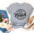 Agate Life’s a Beach Enjoy The Waves T-shirt showing a beach scene with waves and sun illustration on soft fabric.