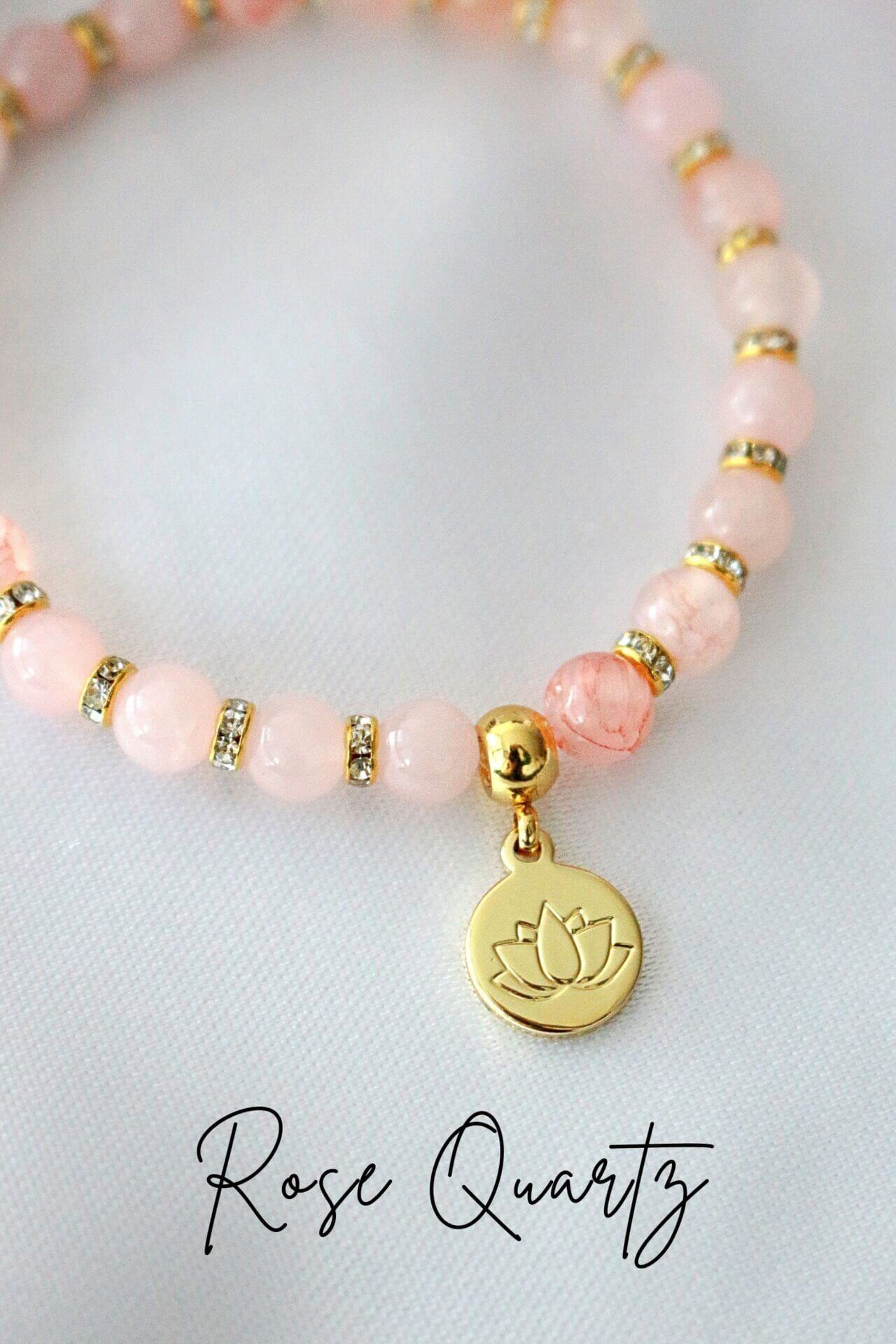 Ultramarine Birch rose quartz and amethyst elastic bracelet with a 24K gold lotus flower charm on a neutral background.