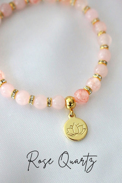 Ultramarine Birch rose quartz and amethyst elastic bracelet with a 24K gold lotus flower charm on a neutral background.