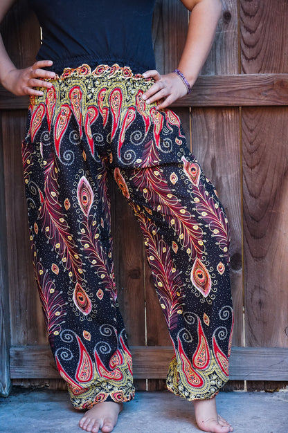 Black peacock boho hippie gypsy pants by Tan Smokey, flowing wide-leg style with intricate feather patterns and relaxed fit.