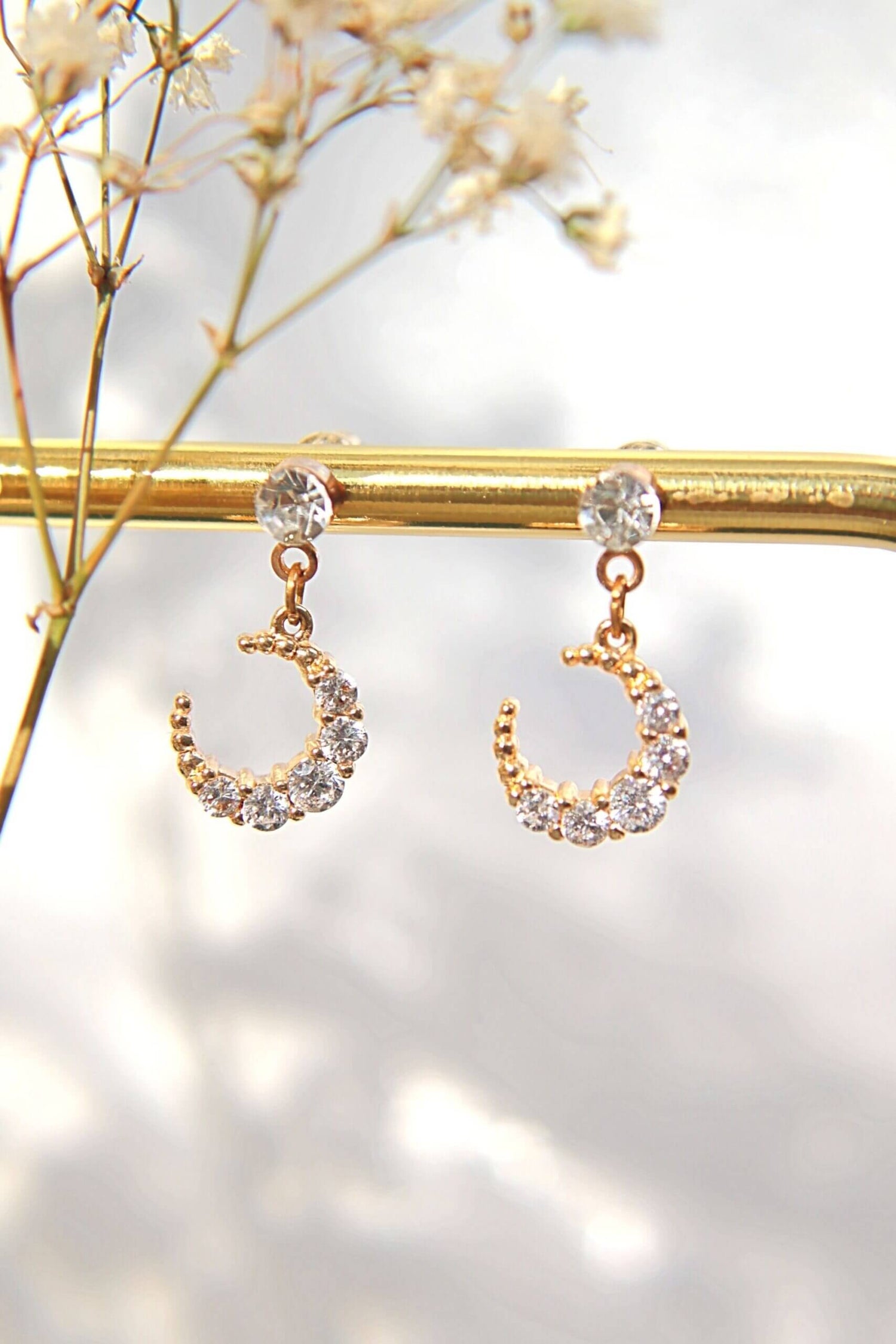 Ultramarine Birch 24 Karat Moon Cubic Zirconia Stud Earrings featuring shimmering moon-shaped zirconia gemstones on silver posts.