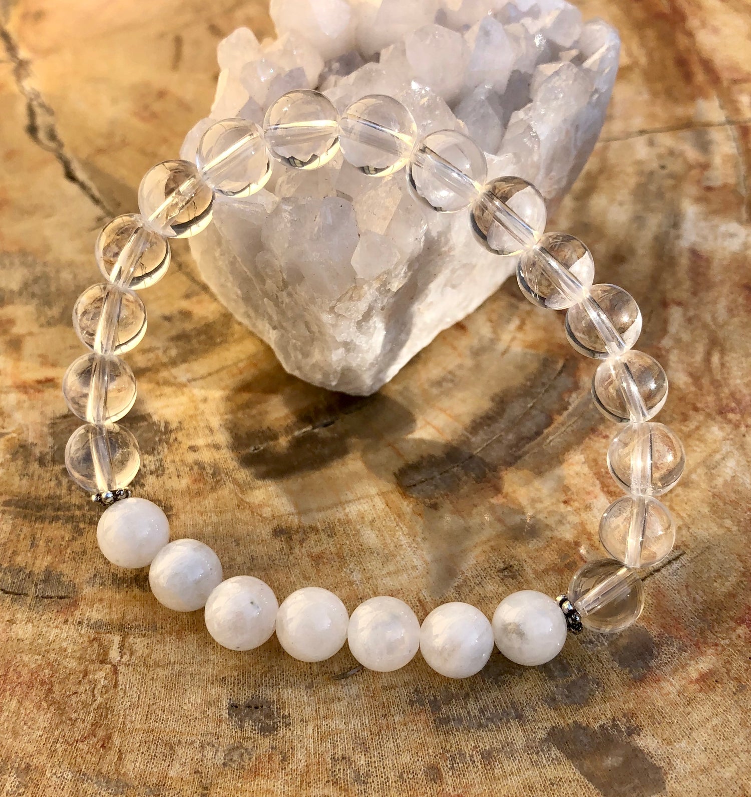 Rainbow Moonstone and Crystal Quartz stretch bracelet featuring genuine crystals on a violet-colored elastic band.