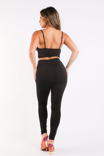 Black mesh contrast sports set by Puce Juniper, includes strappy sleeve top and matching leggings for casual athletic wear.