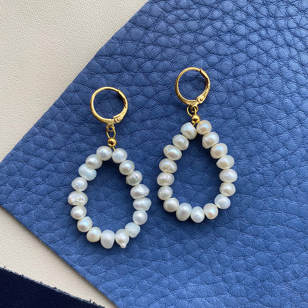 Yellow Athena pearl drop earrings featuring elegant white pearls hanging from delicate gold hooks.