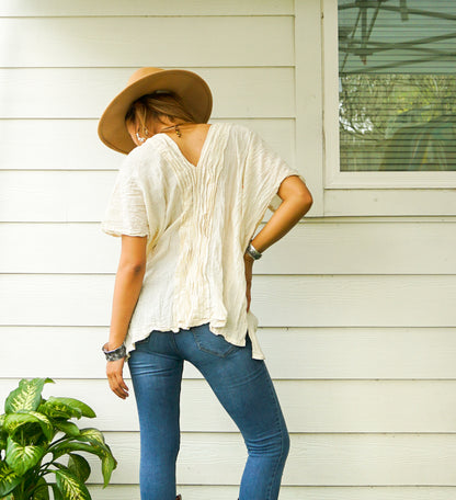 Tan Smokey raw crinkled cotton gauze blouse, lightweight and breathable top with a relaxed fit, shown on a hanger.