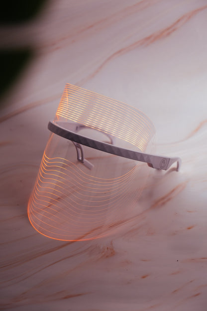 Scarlet Chrysippus Cocoon Skin Enlightenment LED Face Mask with adjustable straps and multiple light therapy panels on a white background.