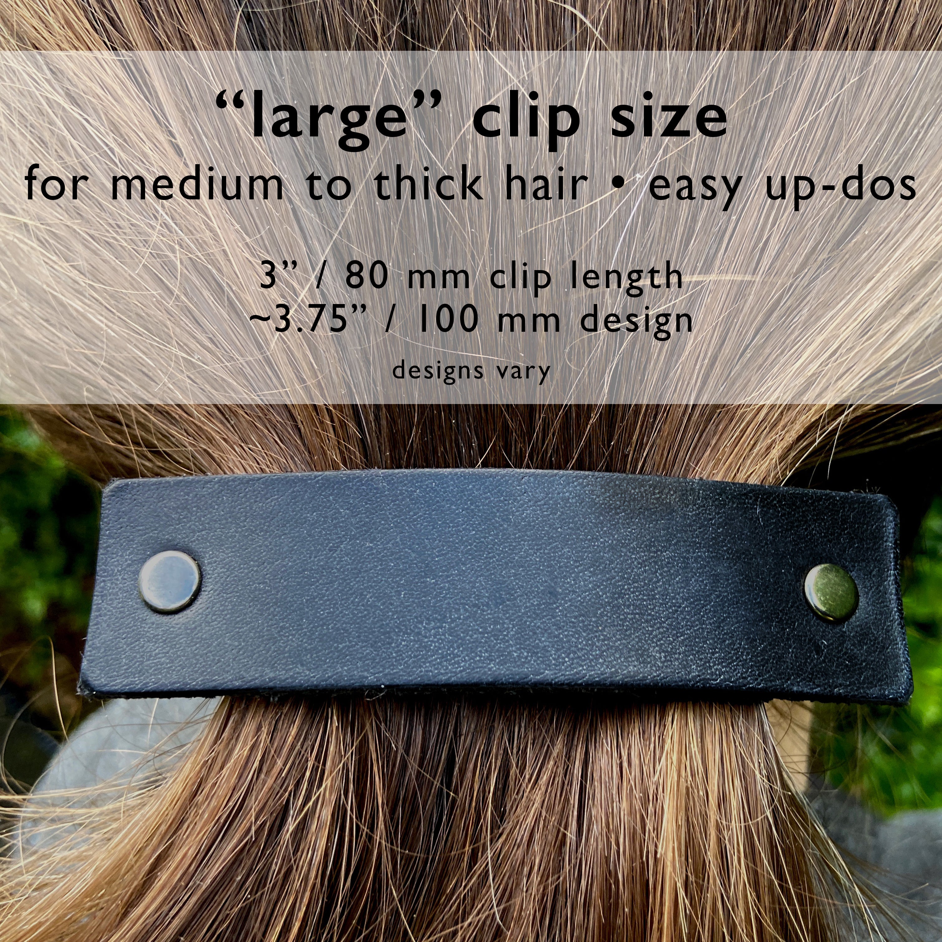 Silver feather on black leather hair barrette by Orange Themis, showcasing an elegant hair accessory with detailed feather design.