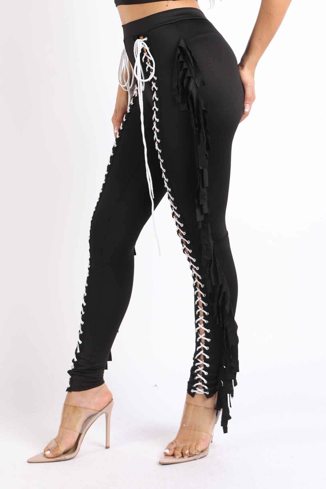 Black lace-up fringe tassel pants leggings by Puce Juniper, featuring detailed fringe tassels and fitted leg design.