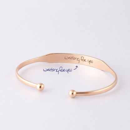 Green Millie handwritten cuff bracelet cufflinks with elegant script design on shiny metal surface