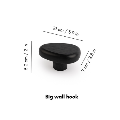 Black wall hook DROP by Biotite for organization, shown mounted on a wall with a sleek, minimalist design.
