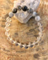 Black Tourmaline and Crystal Quartz stretch bracelet with genuine crystals, featuring black and clear gemstone beads on a flexible band.