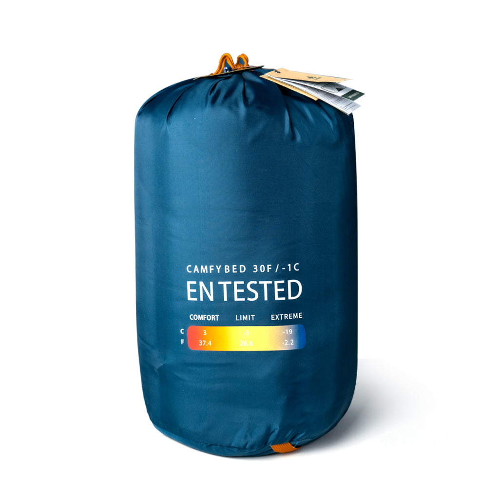 Indigo Eurybia Camfy 30 sleeping bag for camping, shown outdoors with insulated design and adjustable drawstrings.