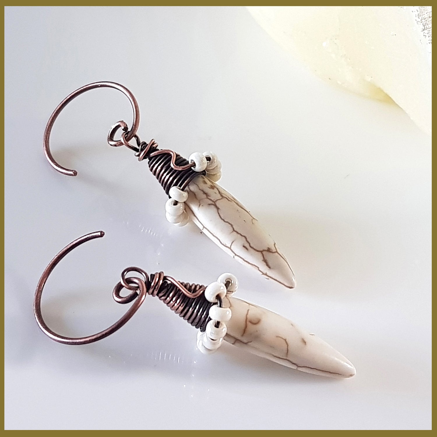 Copper wire wrapped Howlite spike earrings by Maroon Smudge featuring white and gray stone spikes with intricate wire detailing.