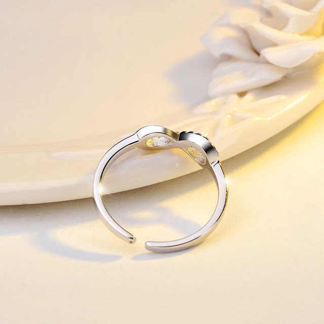 Silver infinity ring by Fuchsia Molly adorned with sparkling rhinestones, showcasing a sleek and elegant design.